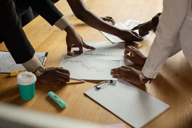 A diverse team collaborates on analyzing data charts during a meeting. Seven content agencies demand signals that shape client budgets