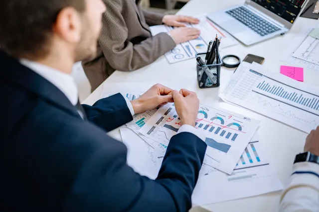 Business team analyzing financial graphs at a meeting table, fostering collaboration in an office environment. Seven steps to define the content agencies target audience
